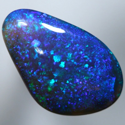 SOLID BLACK CRYSTAL OPAL A pinfire pattern of green and blue